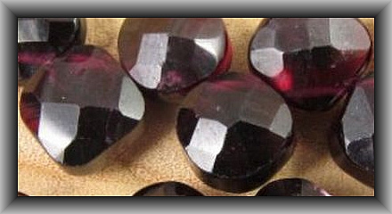 Most stones cut in India are dyed. It is almost an industry standard. This is a garnet which is a stone often cut in India so .... usually dyed.